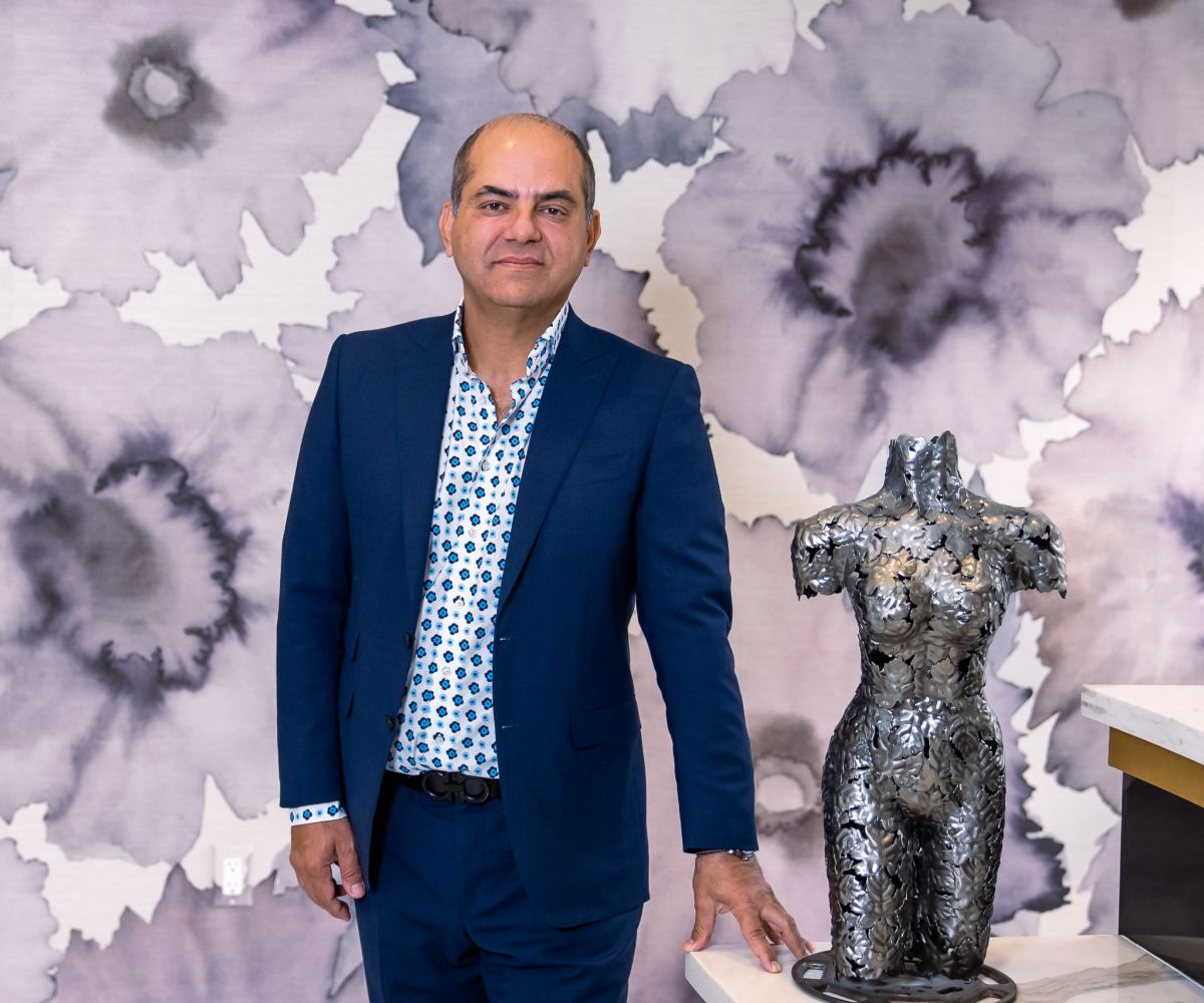 Person standing next to artistic metallic sculpture.